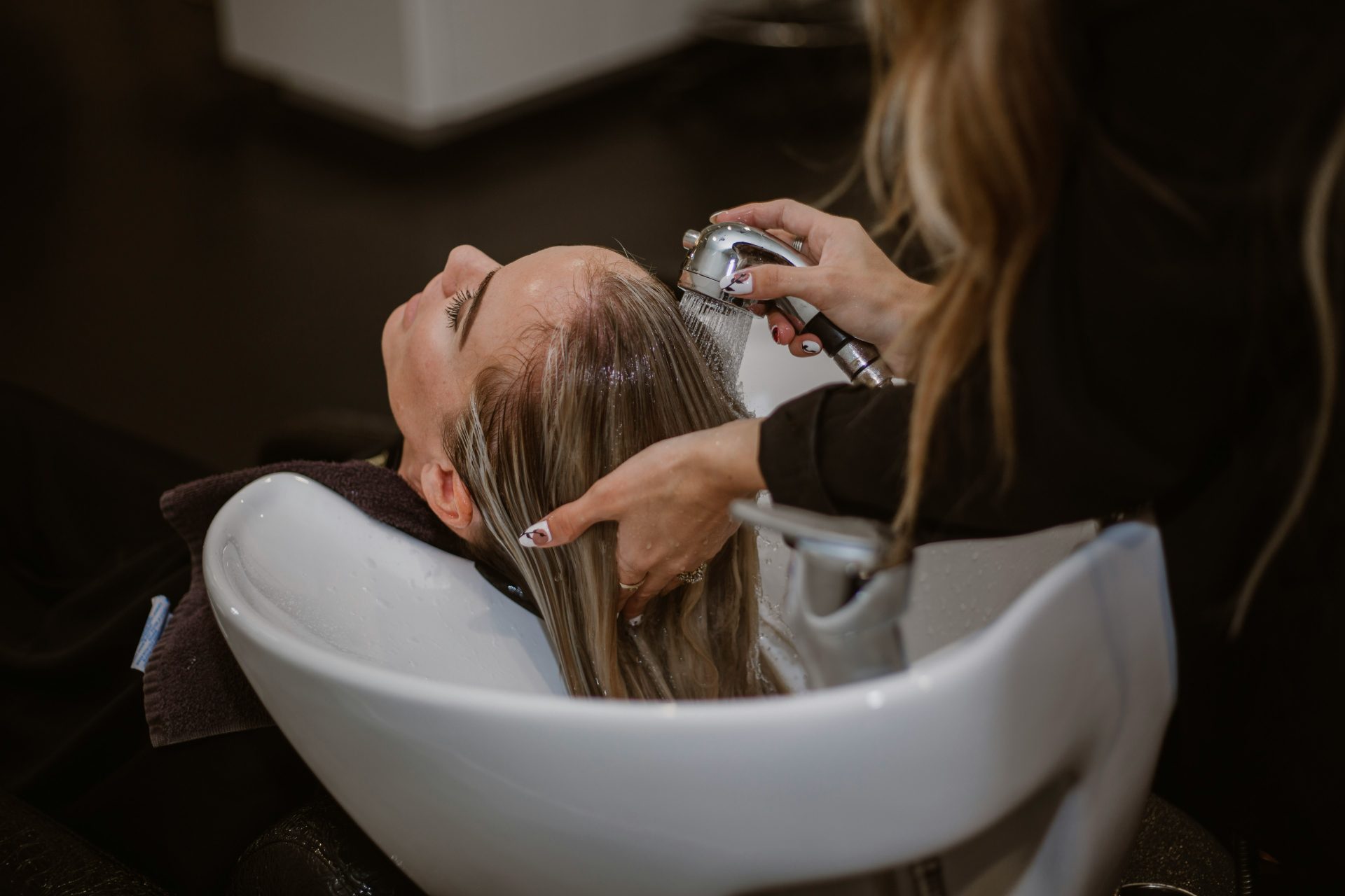 une femme se faisant couper les cheveux par un coiffeur